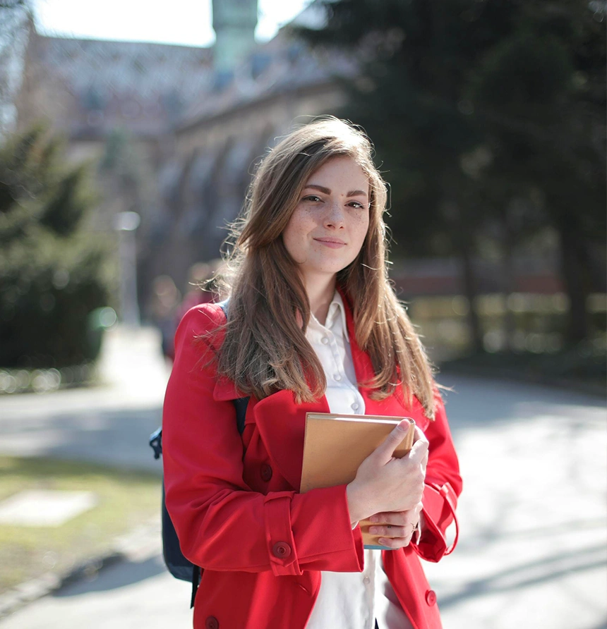 A confident female student with books, looking forward to her study abroad journey through study abroad agencies in kerala